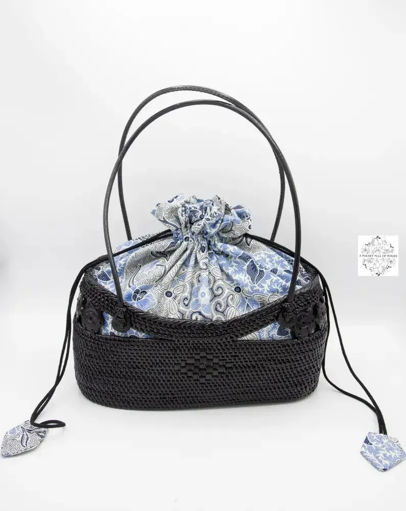 Black boat bag with top handles, blue-white drawstring lining